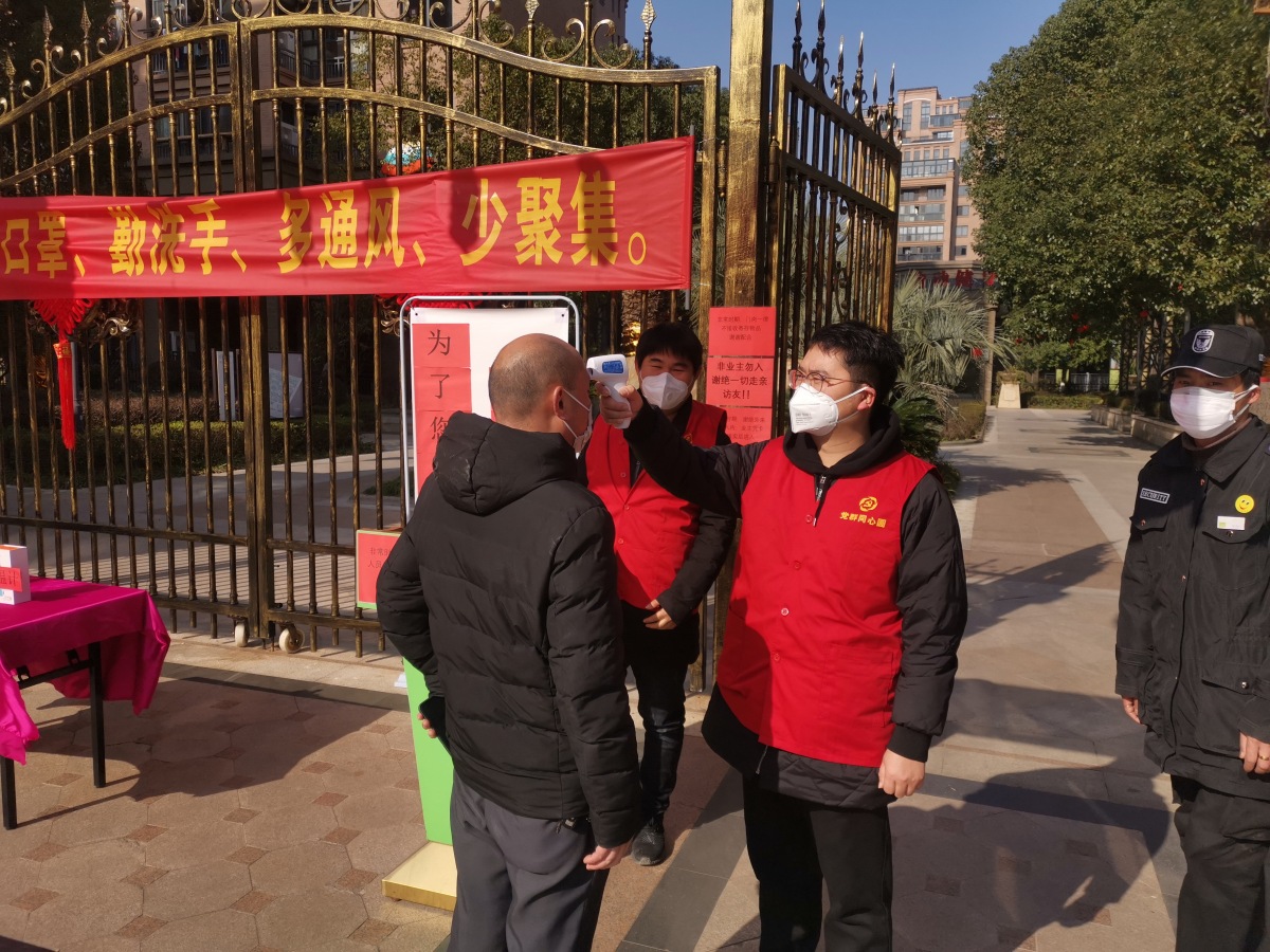 志愿者给小区出入人员测量体温