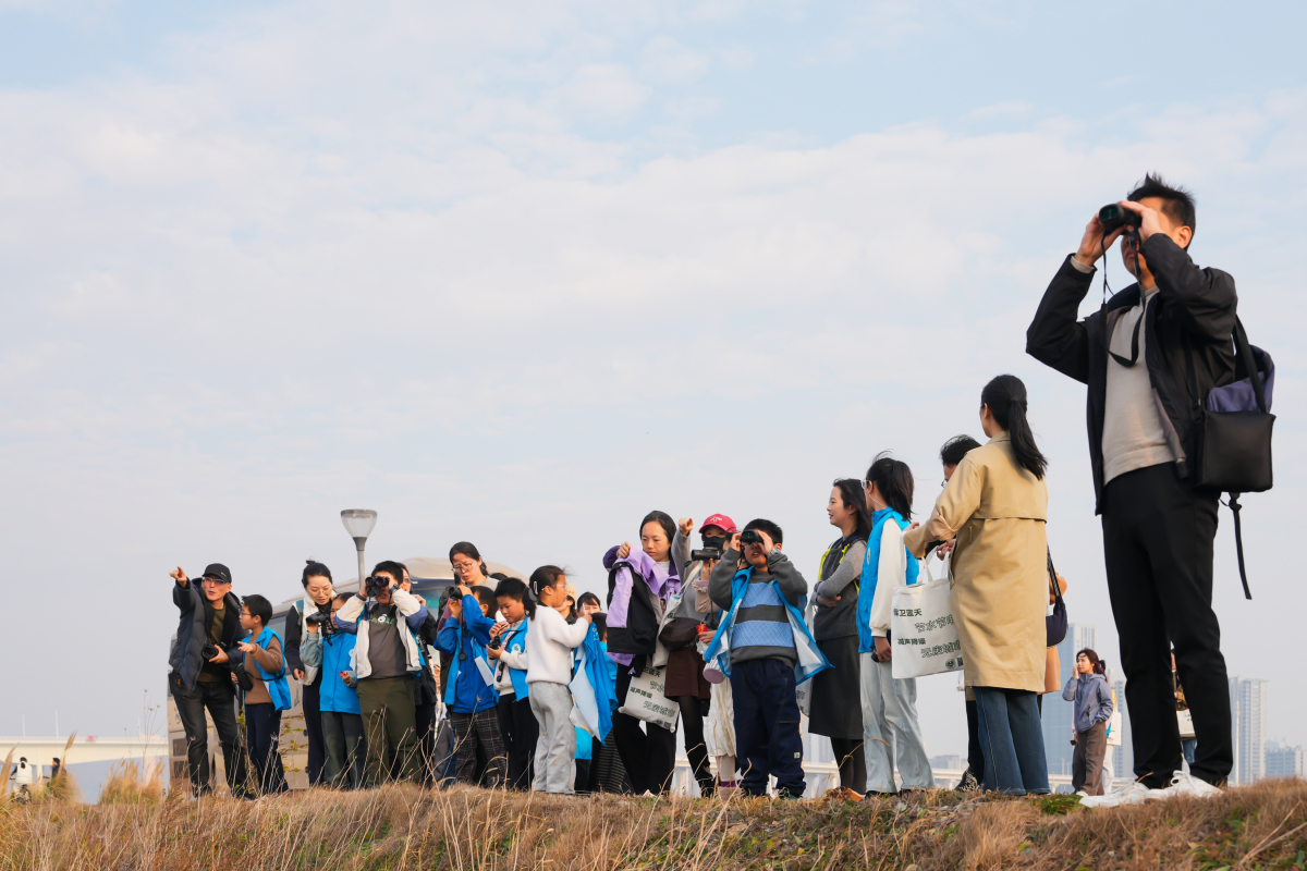 在梅山湾，小朋友们兴奋地举起望远镜观鸟.JPG